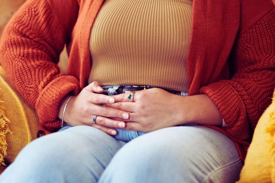 Kobieta trzyma się za bolący brzuch