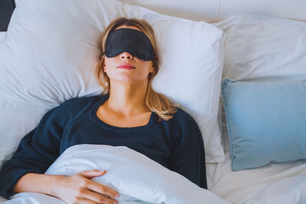 Kobieta śpi w opasce na oczy